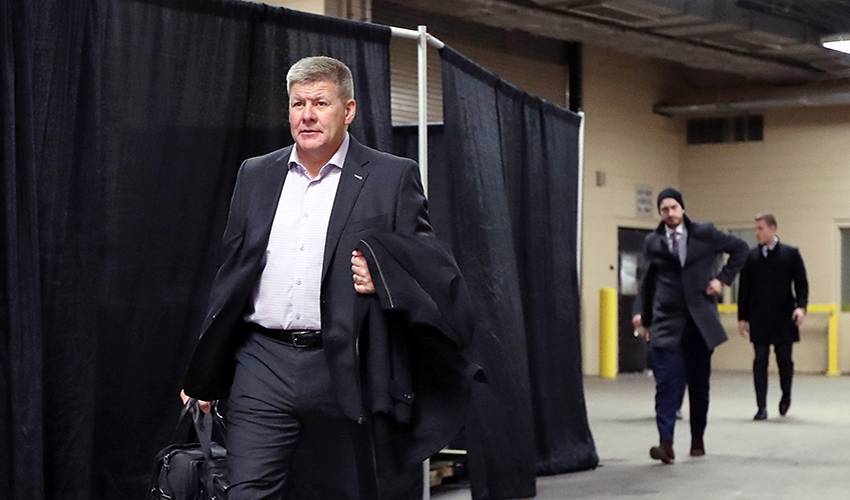 Calgary Flames head coach Bill Peters stands behind Andrew Mangiapane (88)  during the third per …